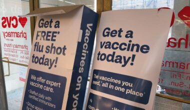 A sign for flu shots at a pharmacy.