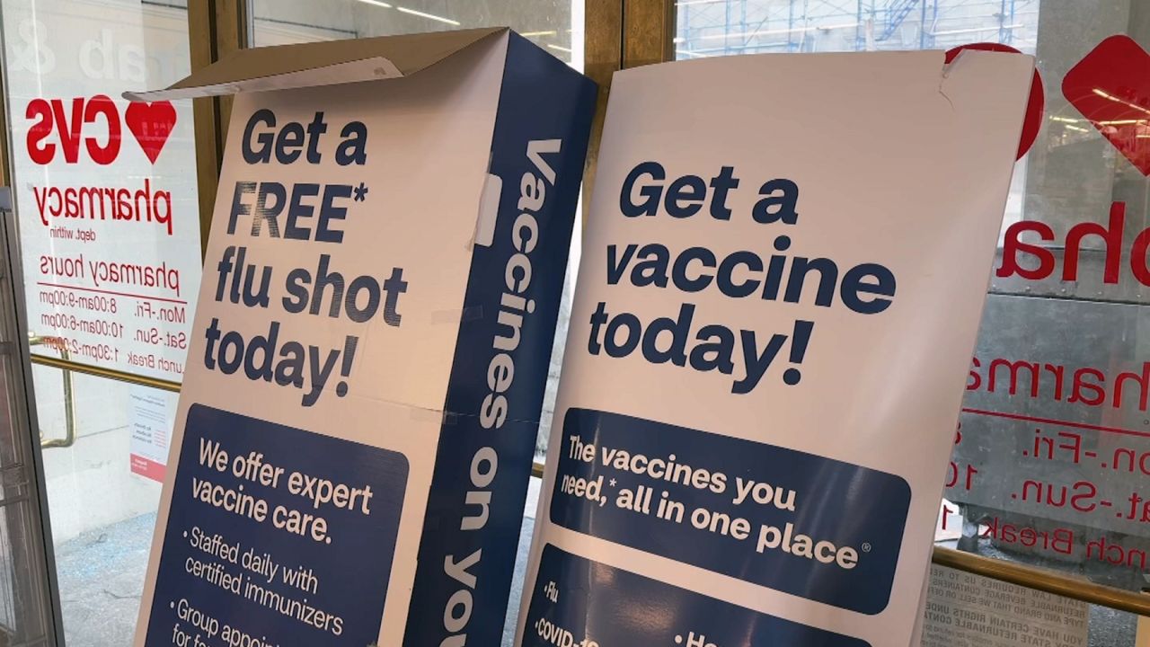 A sign for flu shots at a pharmacy.