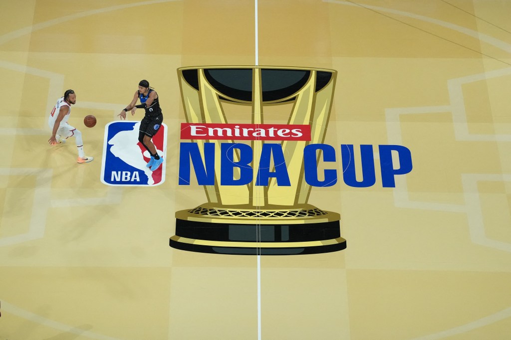 Orlando Magic guard Anthony Black passes the ball as New York Knicks guard Jalen Brunson defends on the court with an "Emirates NBA Cup" logo.