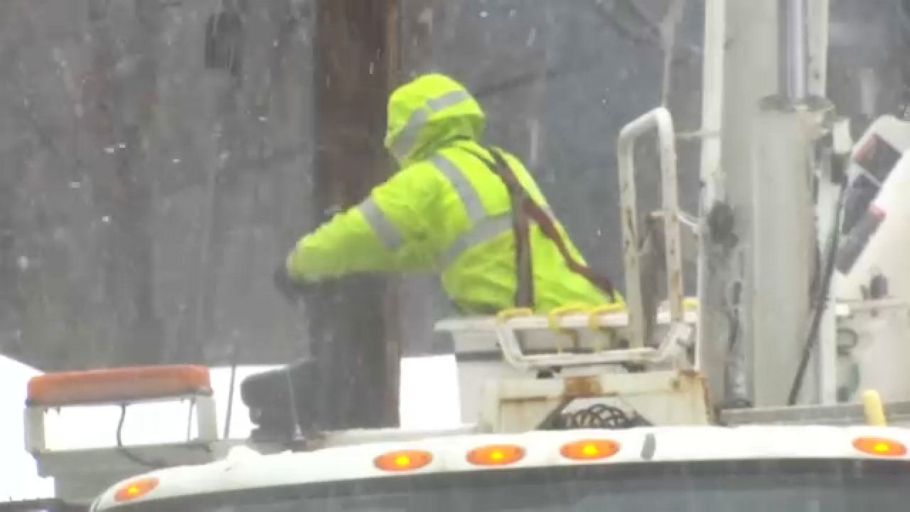 A worker performs maintenance on a power line