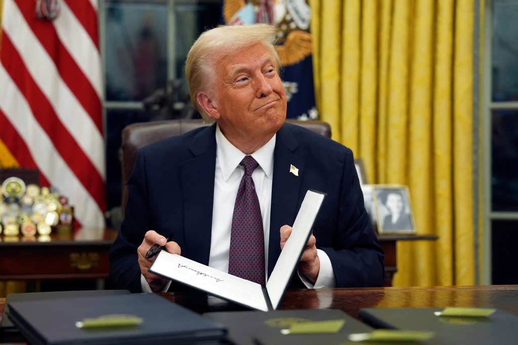 President Donald Trump signs executive orders in the Oval Office.