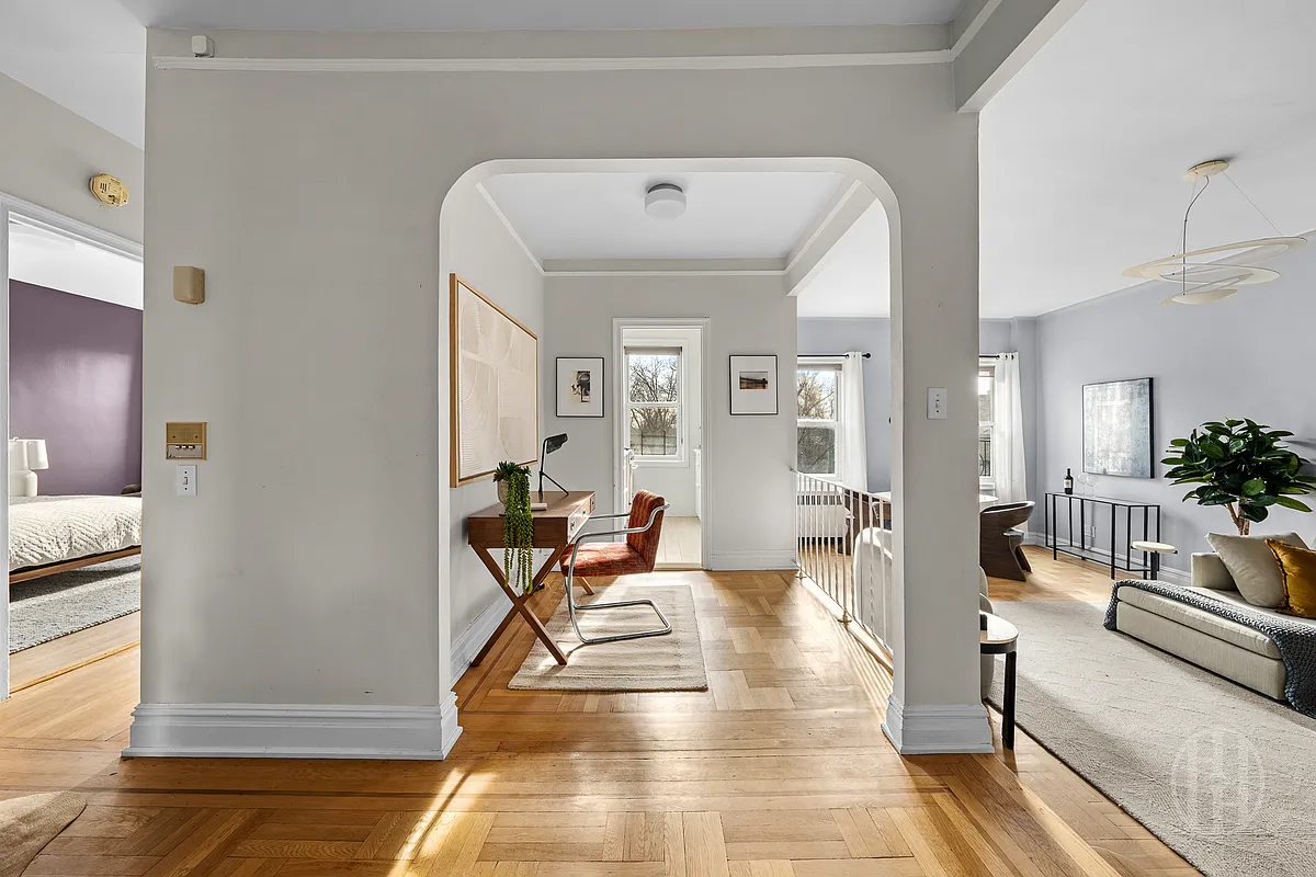 foyer with arched doorway to dining area and step down to  living room