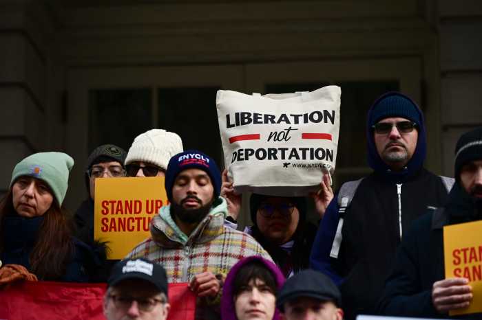 people bundled up for winter, outside at a rally