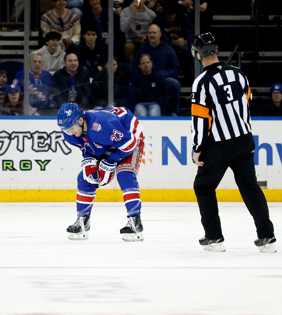 New York Rangers defenseman Adam Fox reacting after taking a hit.