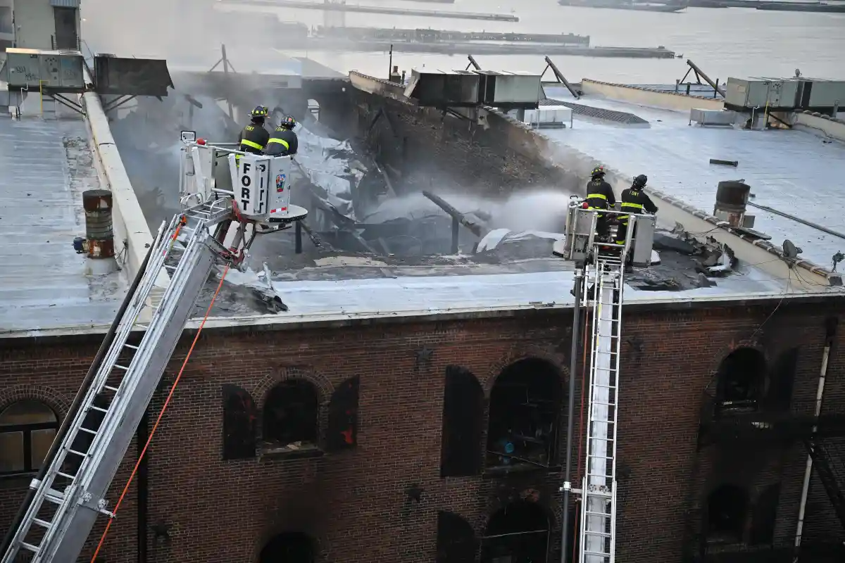 firefighters getting water onto the roof of a warehouse
