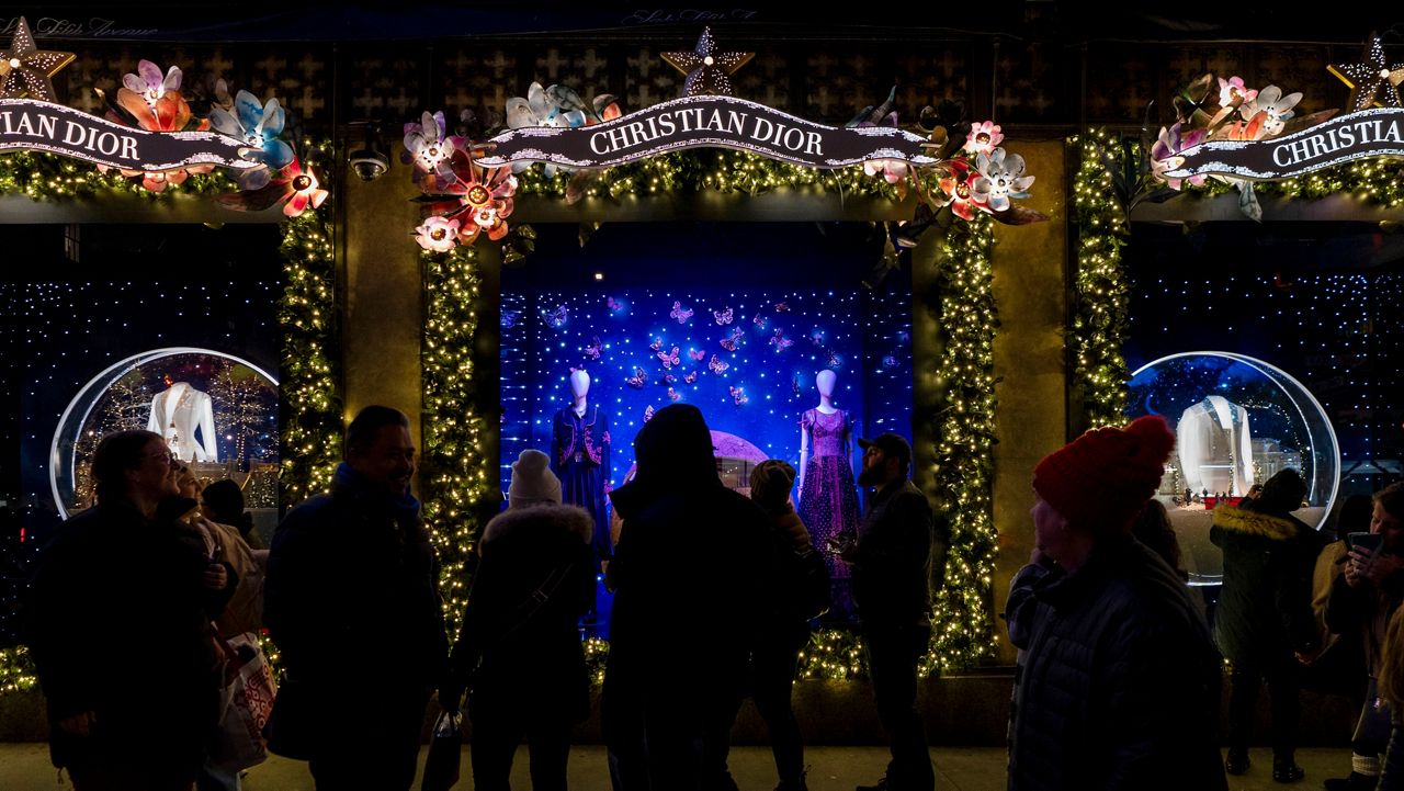 Shoppers and pedestrians walk past a window display at Saks Fifth Avenue in New York, Dec. 14, 2023. (AP Photo/Peter K. Afriyie, File)