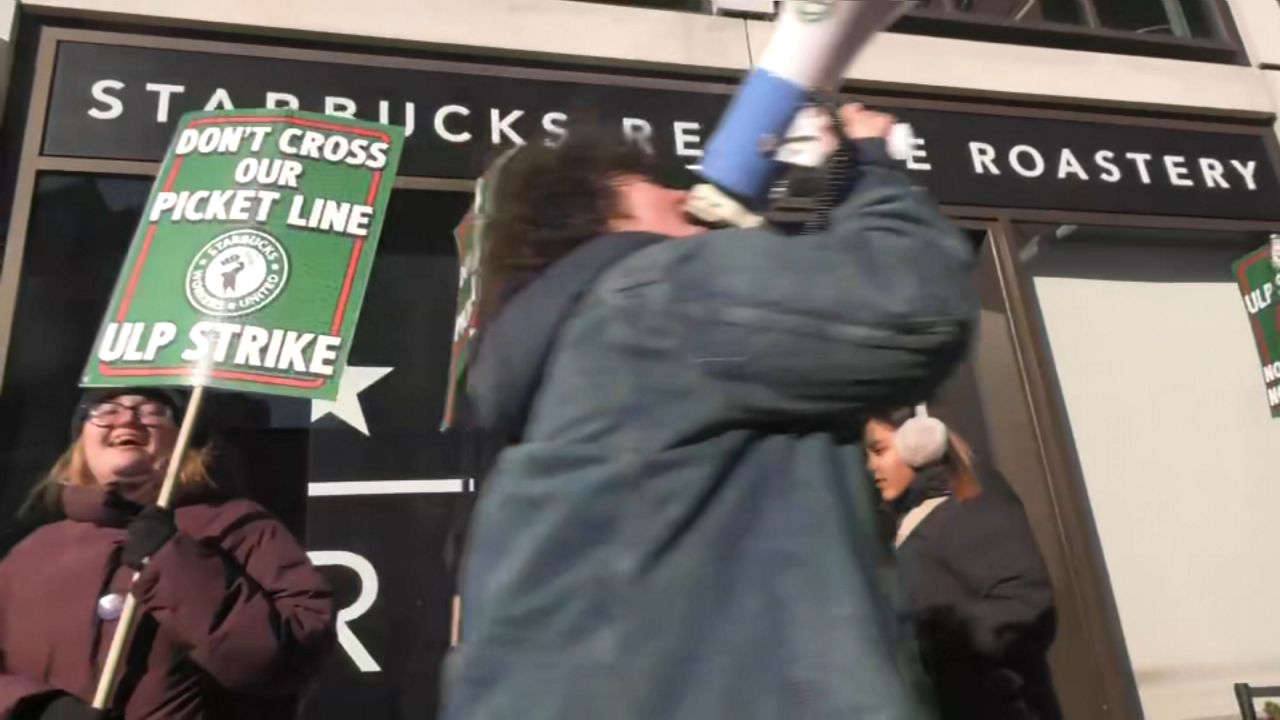 Starbucks employees and supporters picket outside the Starbucks Reserve Roastery in Chelsea on Wednesday, Dec. 24, 2025. (Spectrum News NY1)