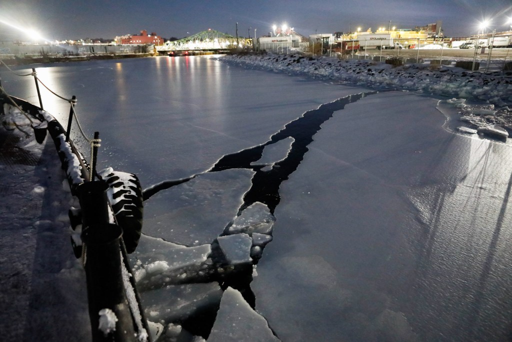 Tugboat operators N.D. Austin and Jean Barberis use the barge to help break up ice in Newtown Creek