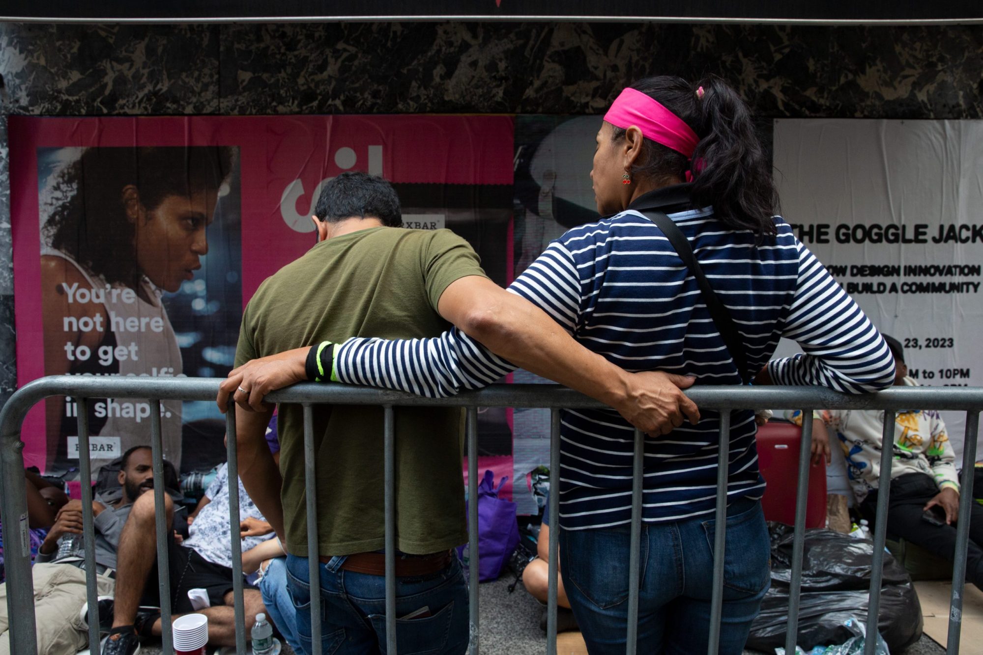 A migrant couple waits in line outside the Roosevelt Hotel shelter.