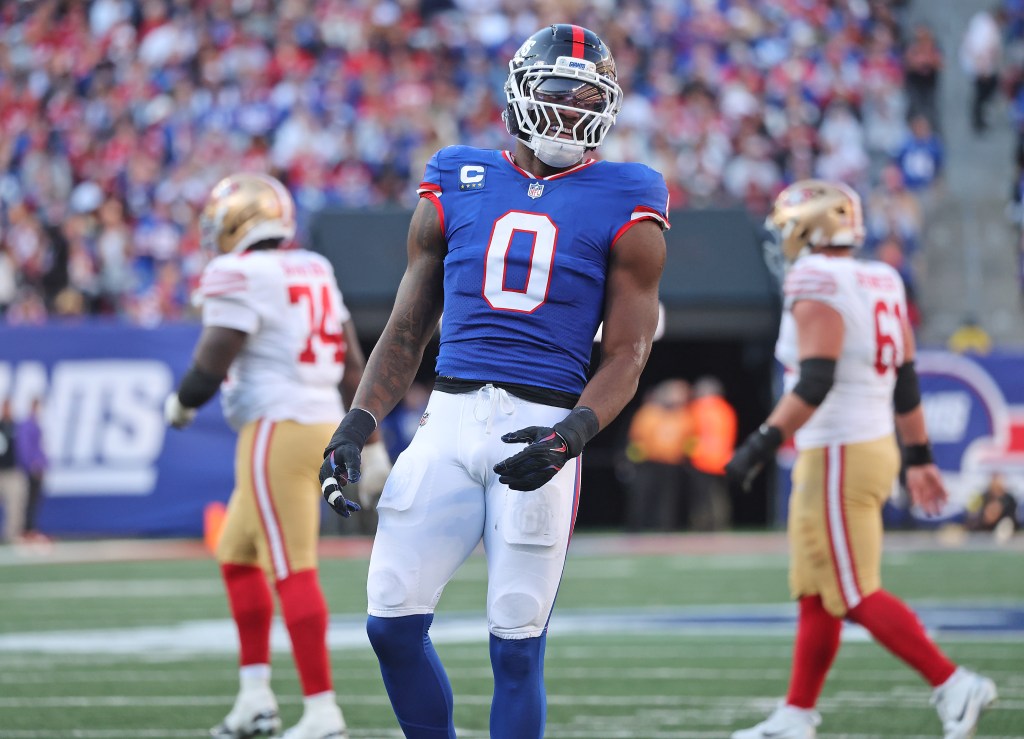 New York Giants player Brian Burns #0, wearing a blue jersey and white pants, on the field during the third quarter.