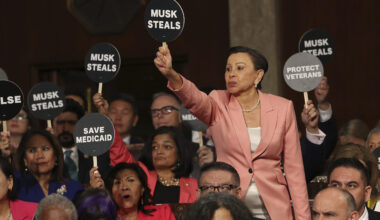 Rep. Nydia Velazquez, D-N.Y., holds a protest sign with fellow Democrats as President Donald Trump addresses a joint session of Congress at the Capitol in Washington, Tuesday, March 4, 2025.