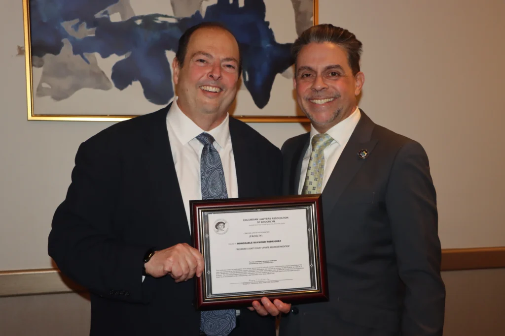 Mario Romano, Esq., left, presenting a CLE “Certificate of Attendance” to Hon. Raymond Rodriguez. Brooklyn Eagle photo by Mario Belluomo