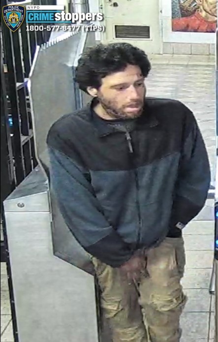 man in a subway station wearing a blue and black jacket