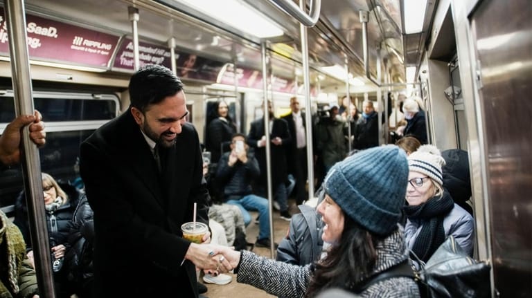 New York City Mayor Zohran Mamdani greets passengers on a...