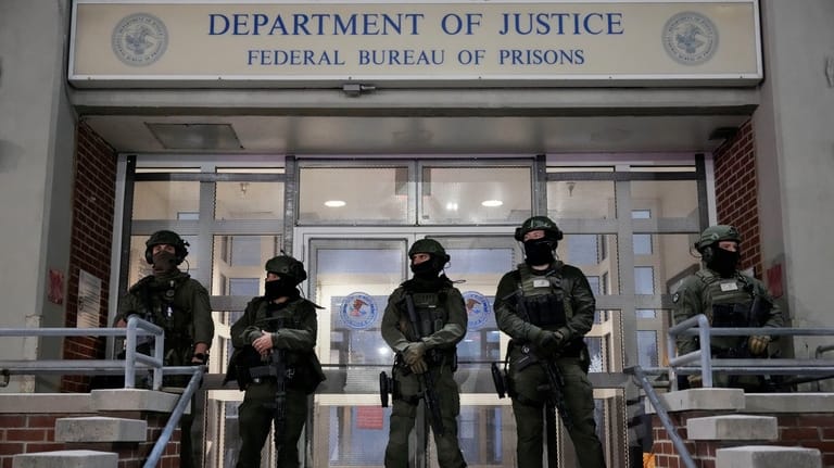Federal law enforcement personnel stand watch outside the Metropolitan Detention...
