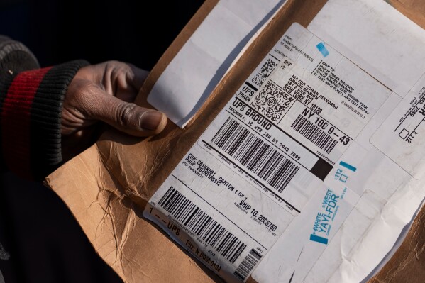 A delivery worker shows a package sent to New York Mayor Zohran Mamdani outside Gracie Mansion, Monday, Jan. 12, 2026, in New York. (AP Photo/Yuki Iwamura)