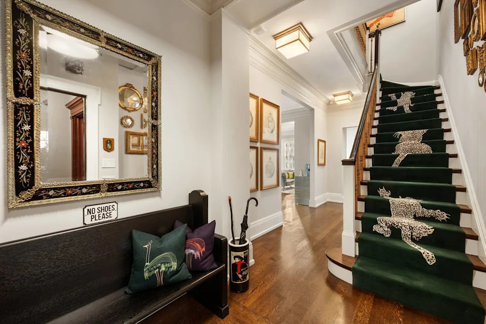 Interior hallway featuring a staircase with patterned carpeting and decorative elements.