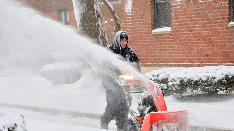 Ever Bonilla works with a snowblower on Welwyn Road in...