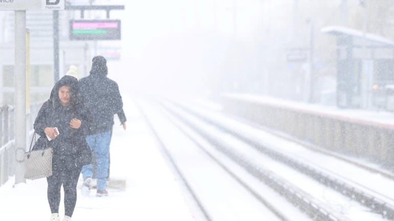 Veronica Bercian battles the cold and snow as she waits for...