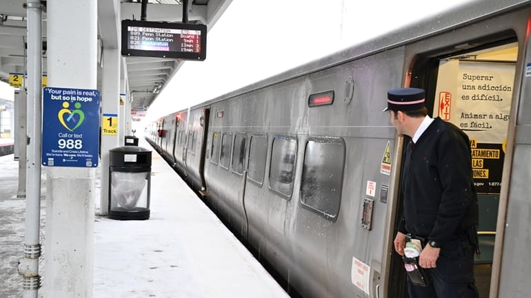 A train conductor looks out at the platform of the...
