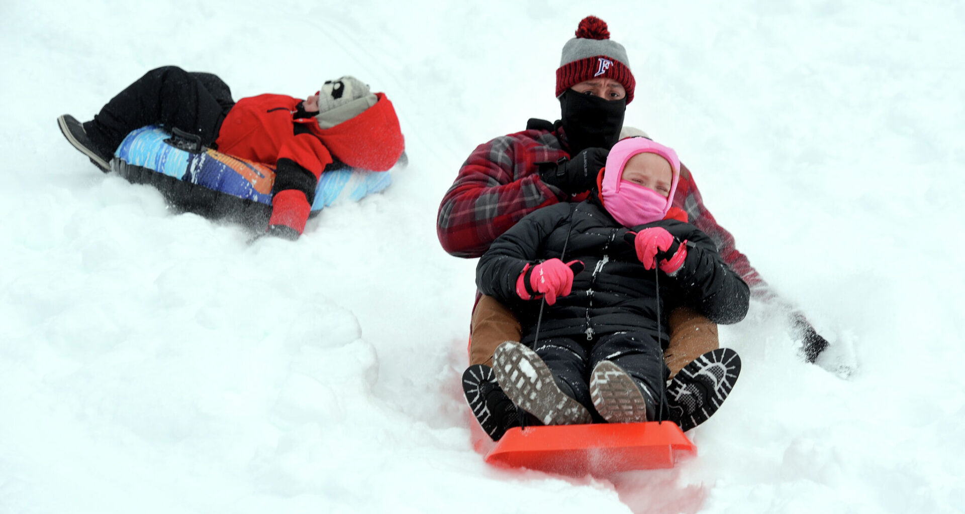 Schools across Connecticut were closed Monday due to the winter storm, which allowed kids to enjoy the snow. Howard Kelly of Bridgeport sleds down a hill at Beardsley Park in Bridgeport with his daughter, Madison, 9, on January 26, 2026 after a foot of snow fell the previous day. Kelly’s son, Jackson, 4, sleds behind them.