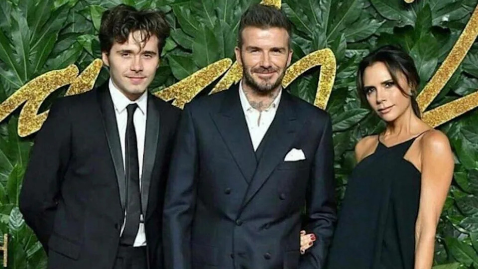 Brooklyn Beckham with his parents David and Victoria Beckham at a red carpet event