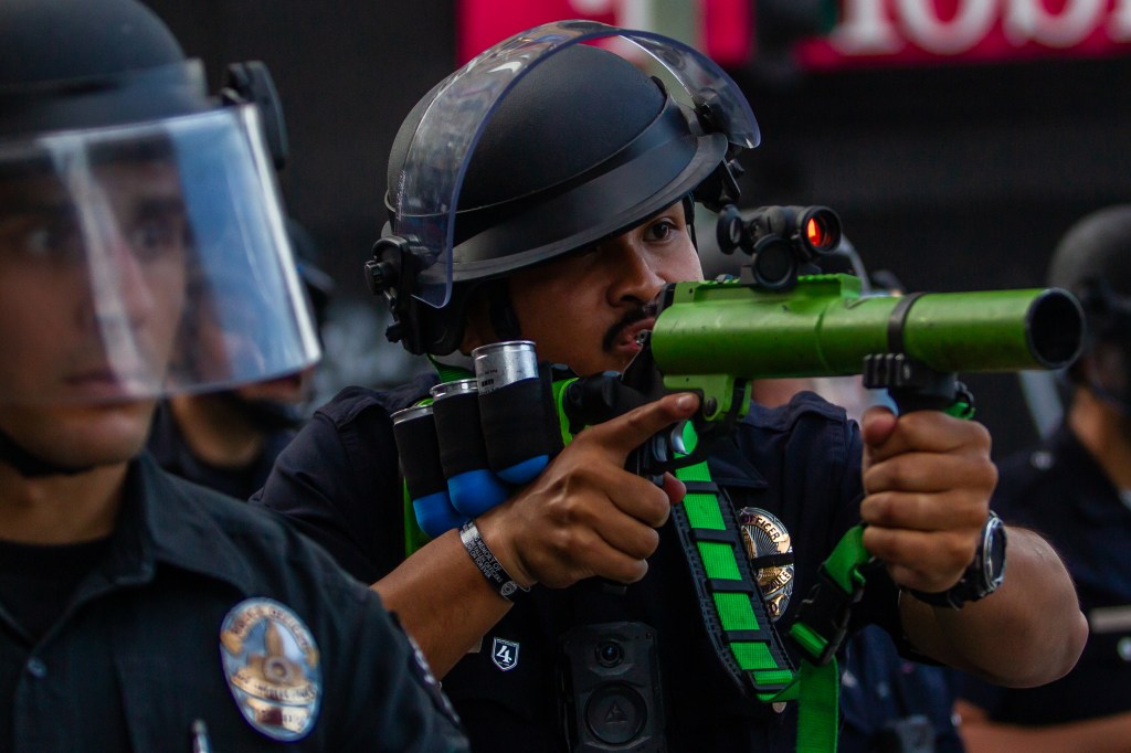 A Los Angeles Police Officer points his rubber bullet gun at a crowd during a protest.