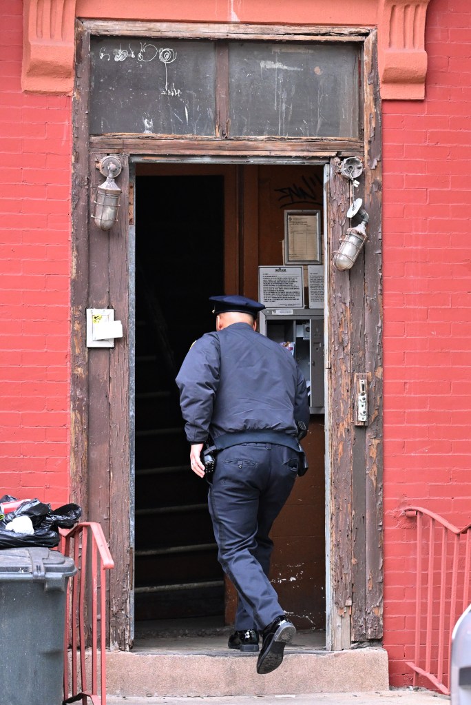 A police officer entering a residential building where a woman was stabbed to death.
