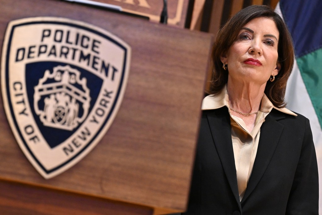 NYS governor Kathy Hochul speaking next to the NYPD emblem.