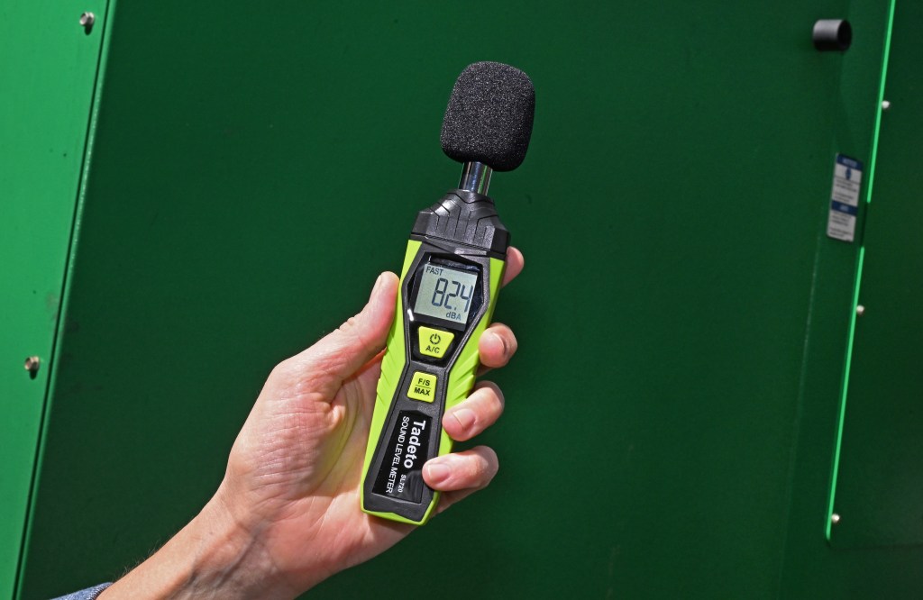 A hand holds a noise reader.