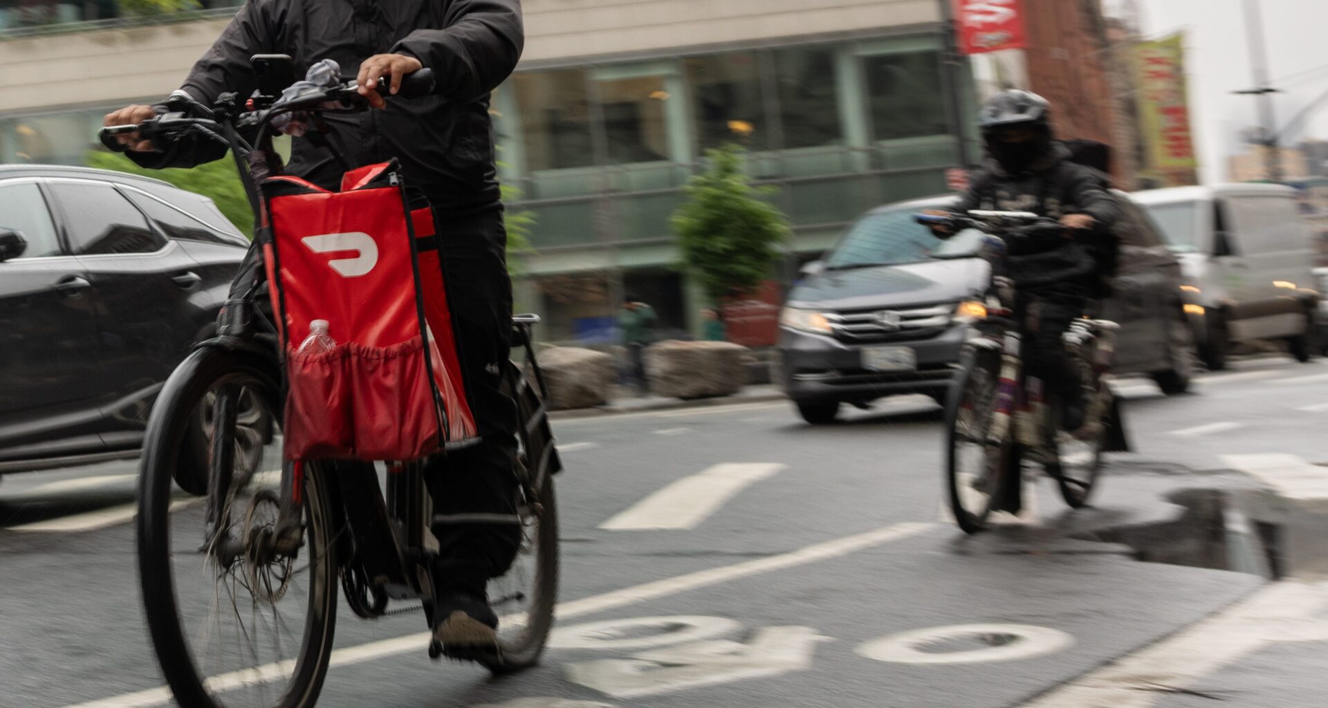 A delivery worker carries a DoorDash bag during a delivery in New York