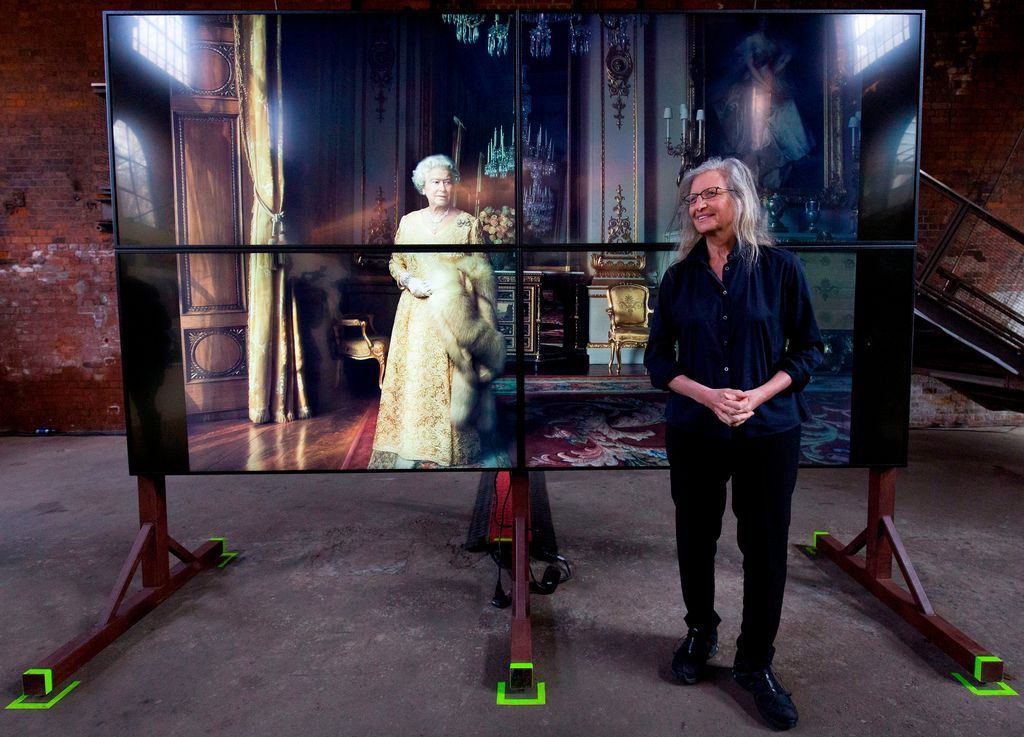 Annie Leibovitz posing in front of a photograph of Britain's Queen Elizabeth II during a photocall to promote her exhibition in 2016