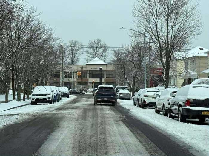 snow in a street and on cars