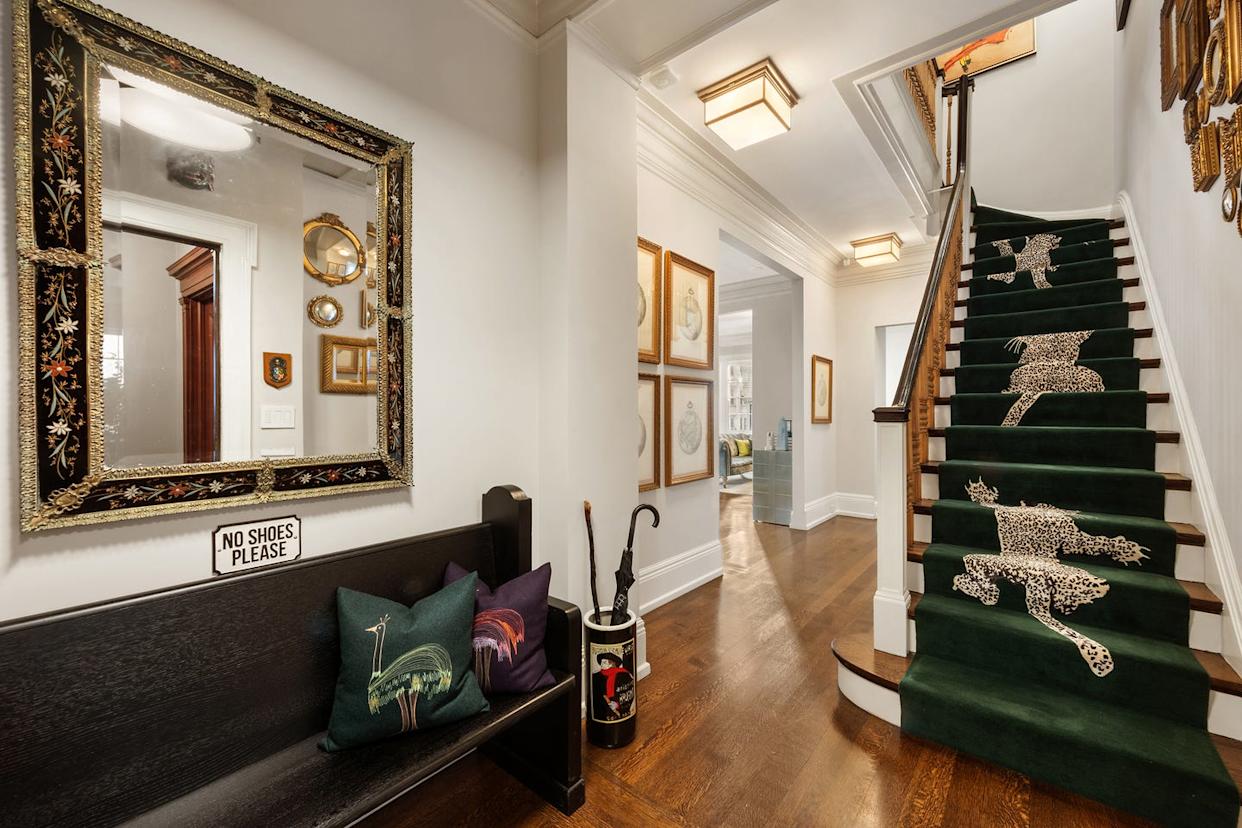 Interior hallway featuring a staircase with patterned carpeting and decorative elements.