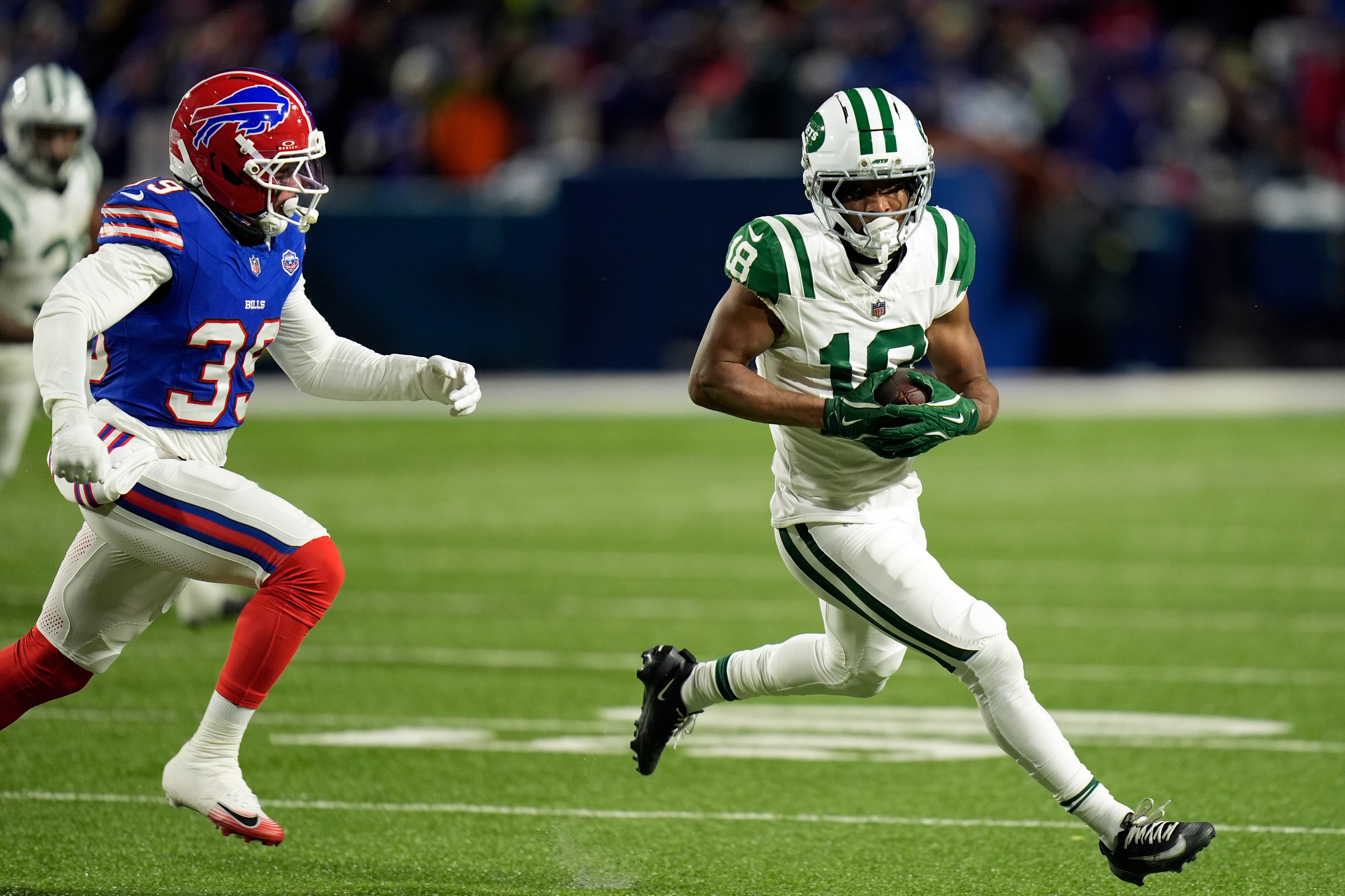 New York Jets wide receiver Isaiah Williams (18) carries the ball as he is defended by Buffalo Bills cornerback Cam Lewis (39) in the first half of an NFL football game Sunday, Jan. 4, 2026, in Orchard Park, N.Y. (AP Photo/Seth Wenig)