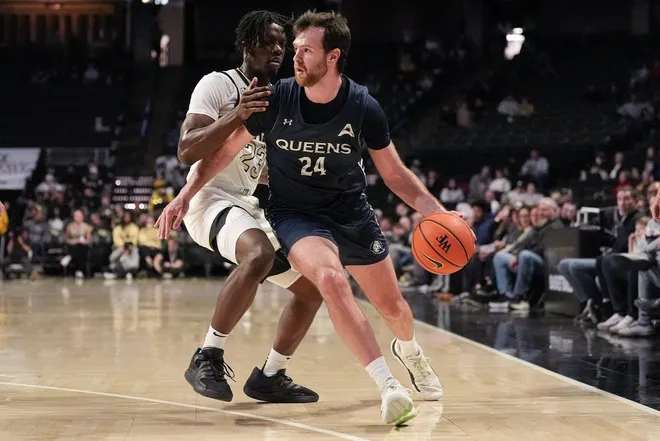 Dec 14, 2025; Winston-Salem, North Carolina, USA; Queens University Royals guard Yoav Berman (24) dribbles the ball defended by Wake Forest Demon Deacons forward Jaylen Cross (23) during the second half at Lawrence Joel Veterans Memorial Coliseum.