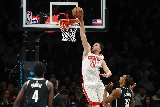 Jan 1, 2026; Brooklyn, New York, USA; Houston Rockets center Alperen Sengun (28) goes up for a dunk in front of Brooklyn Nets center Nic Claxton (33) during the first half at Barclays Center.