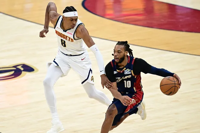 Jan 2, 2026; Cleveland, Ohio, USA; Cleveland Cavaliers guard Darius Garland (10) dribbles up court while being pressured by Denver Nuggets guard Peyton Watson (8) during the second half at Rocket Arena.