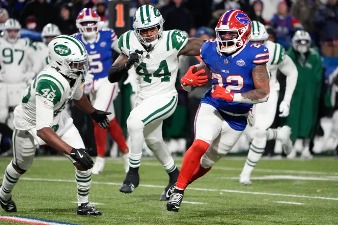 Jan 4, 2026; Orchard Park, New York, USA; Buffalo Bills running back Ray Davis (22) carries the ball defended by New York Jets safety Keidron Smith (46) and linebacker Jamien Sherwood (44) during the second half at Highmark Stadium. Mandatory Credit: Gregory Fisher-Imagn Images