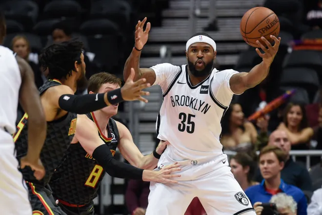Dec 4, 2017; Atlanta, GA, USA; Brooklyn Nets forward Trevor Booker (35) reaches to control the ball against Atlanta Hawks forward Luke Babbitt (8) and forward DeAndre' Bembry (95) during the first half at Philips Arena. Mandatory Credit: Dale Zanine-USA TODAY Sports