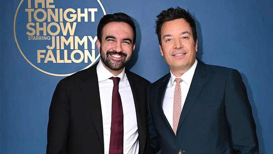 Zohran Mamdani and Jimmy Fallon stand together smiling backstage at a television studio.