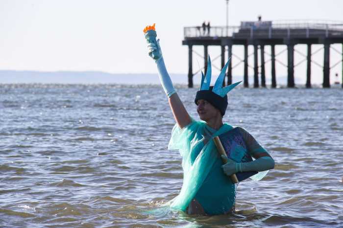 woman dressed as statue of liberty in ocean