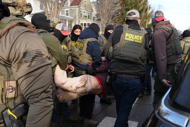 A protester is detained by Federal agents near the scene where Renee Good was fatally shot by an ICE officer last week, Tuesday, Jan. 13, 2026, in Minneapolis.(AP Photo/Adam Gray)