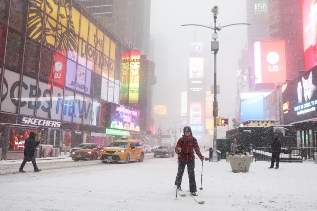 A person cross-country skis through Times Square during a winter storm, Sunday, Jan. 25, 2026, in New York. (AP Photo/Heather Khalifa)