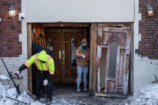 People clean up the scene where a car slammed into the entrance of the Chabad Lubavitch world headquarters, Thursday, Jan. 29, 2026, in New York. (AP Photo/Yuki Iwamura)