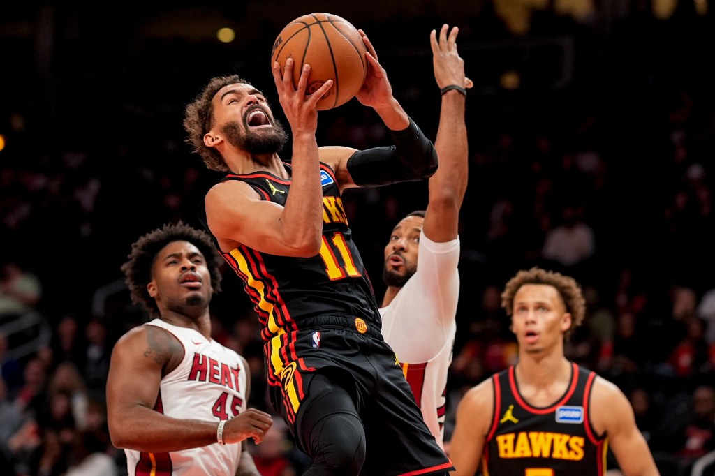 Atlanta Hawks guard Trae Young (11) shoots past Miami Heat guard Davion Mitchell (45) during the first half of an NBA basketball game, Friday, Dec. 26, 2025, in Atlanta. 