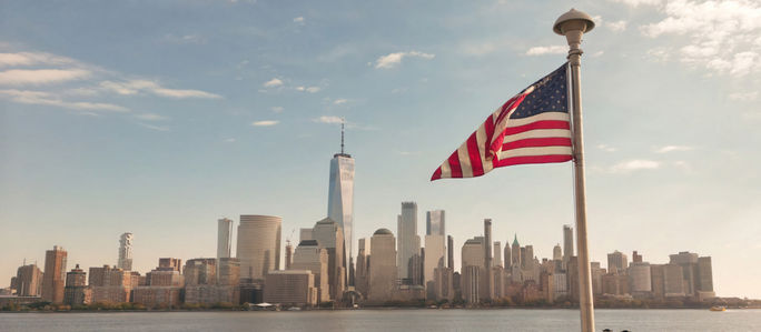 American flag waves in front of New York City skyline