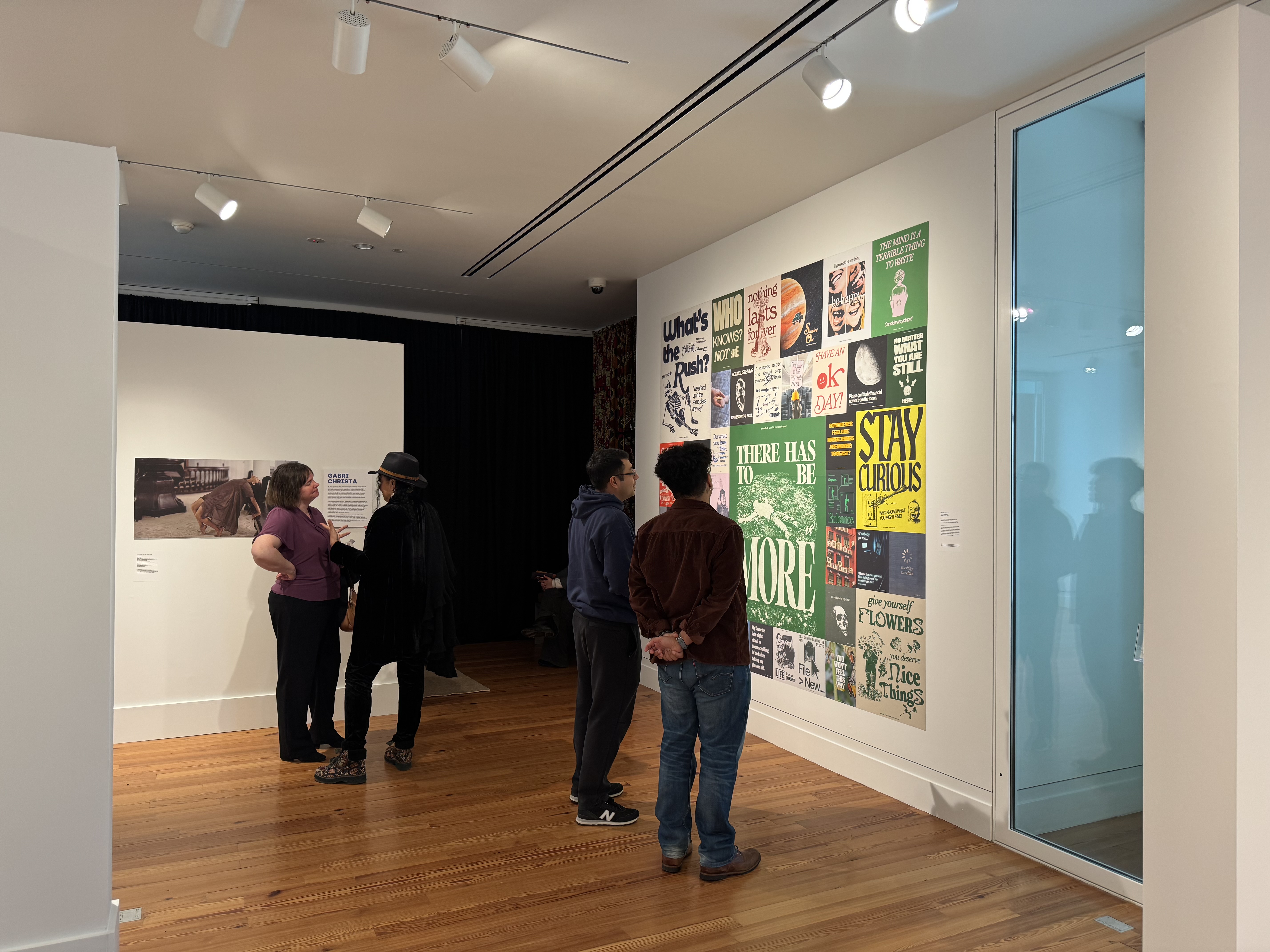 Roemello Agjmurati and Arjuna Routté-Prieur talk in front of a collage of work by Agjmurati Claire Hamlet