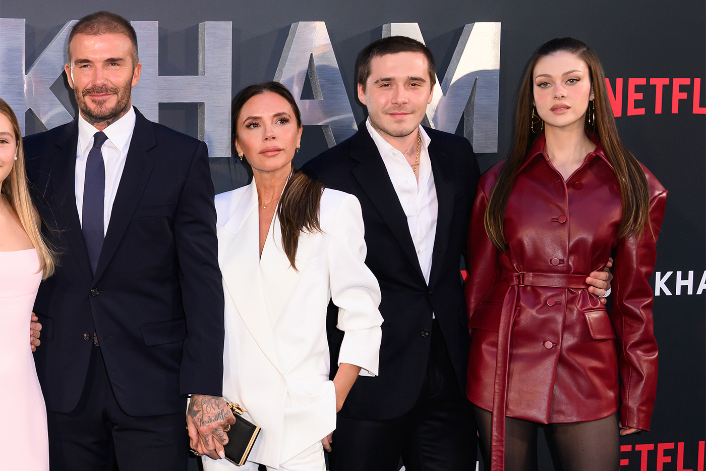 Harper Beckham, David Beckham, Victoria Beckham, Brooklyn Beckham, and Nicola Peltz posing on the red carpet at a Netflix premiere of the 'Beckham' docuseries.
