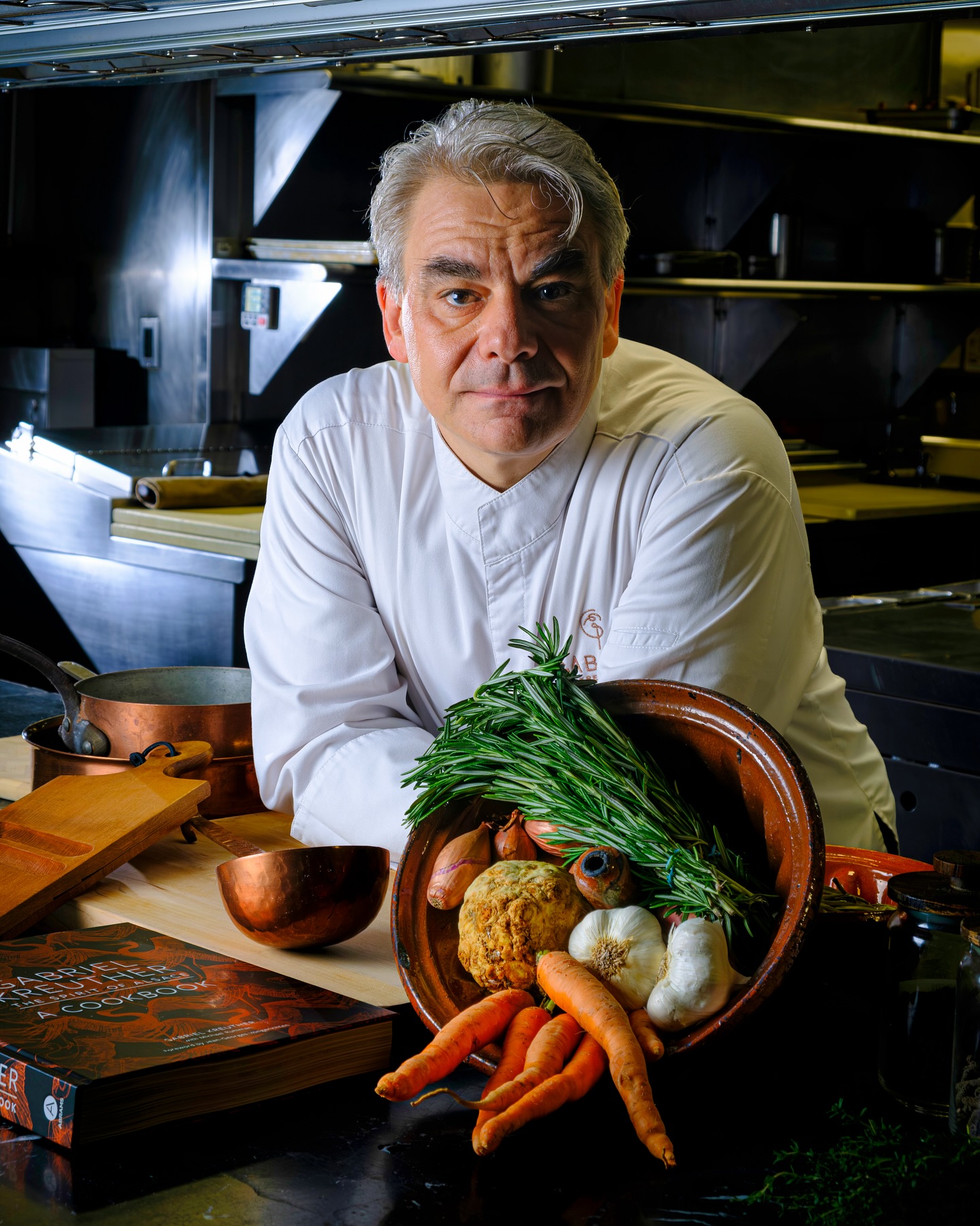 A chef stands in his kitchen.